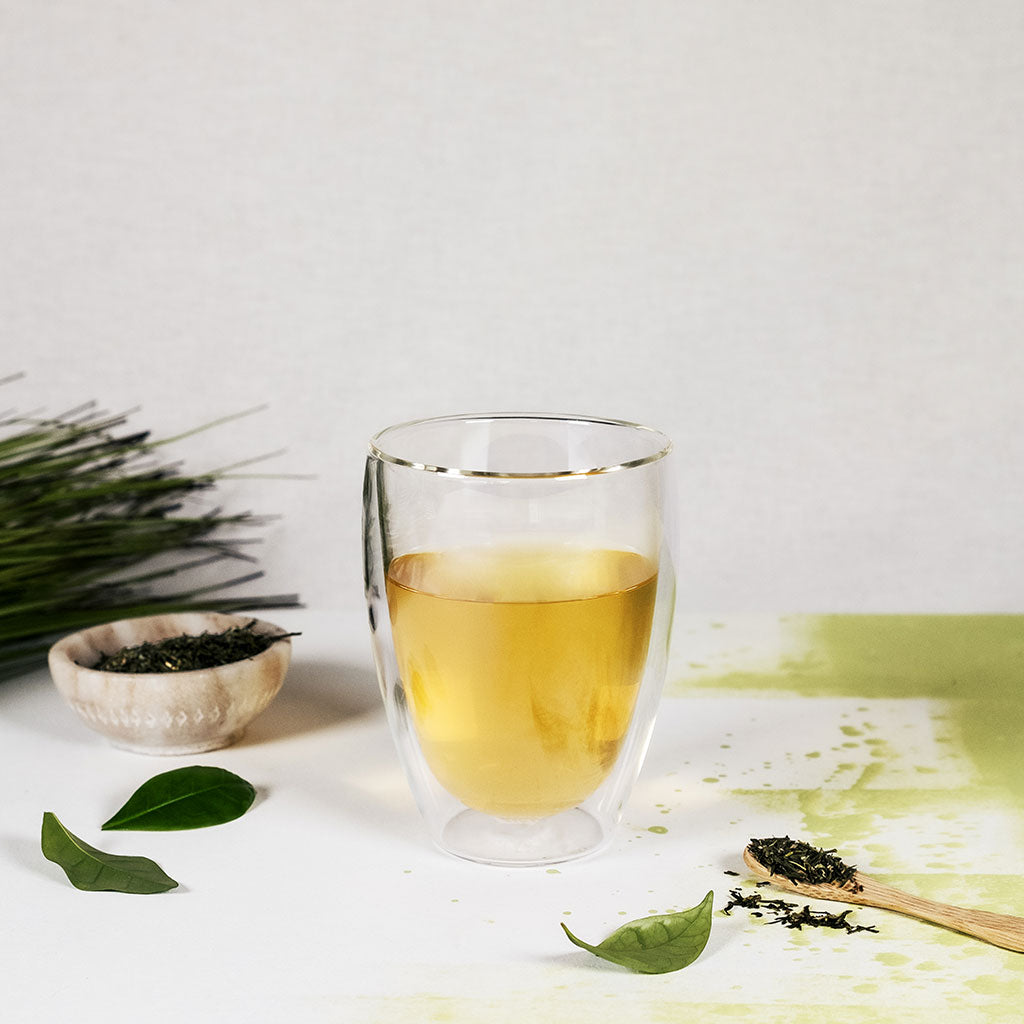 Das Bild zeigt eines der doppelwandigen Teegläser mit aufgegossenem grünem Tee.